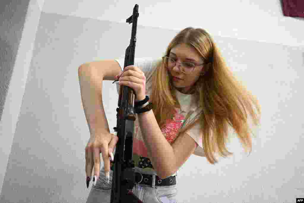 A girl dismantles a Kalashnikov rifle during a training lesson focused on the &quot;Defence of Ukraine&quot; at the military-patriotic center for schoolchildren in Lviv, amid the Russian invasion of Ukraine.