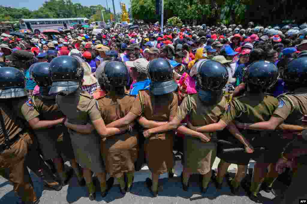 Policewoman stand guard as anti-government demonstrators take part in a protest organized by the &quot;Women for Rights&quot; group on the occasion of International Women&#39;s Day near the parliament building in Colombo, Sri Lanka.