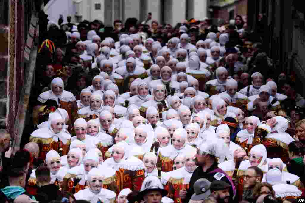Revelers dressed as a &quot;Gilles&quot;, the oldest and principal participants in the Carnival of Binche in Belgium, take part in the parade in Binche, Belgium.