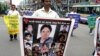 ২০০৪ সালের গ্রেনেড হামলার বার্ষিকী উপলক্ষে নিহতদের ছবির একটি পোস্টার নিয়ে মিছিল করছেন আওয়ামী যুবলীগের একজন সদস্য। (ফাইল ছবি) 