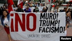 Activistas protestan por la visita del presidente Donald Trump a San Diego, California, en donde examinará este martes prototipos del muro fronterizo que planea construir en la frontera con México.