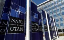 Banners displaying the NATO logo are placed at the entrance of new NATO headquarters during the move to the new building, March 18, 2021.