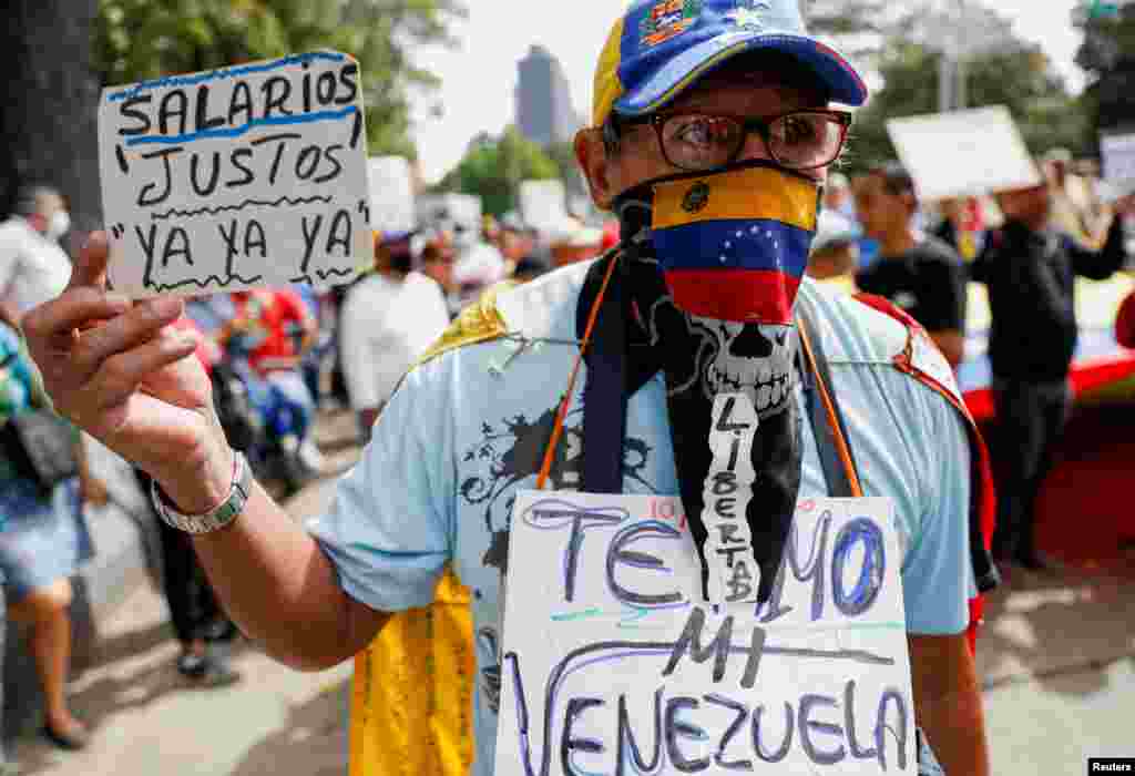 A demonstrator holds a sign that reads &quot;Fair Salaries Now&quot; during a march to demand better salaries in Caracas, Venezuela, as the government of President Nicolas Maduro faces renewed challenges in its attempt to fight inflation.
