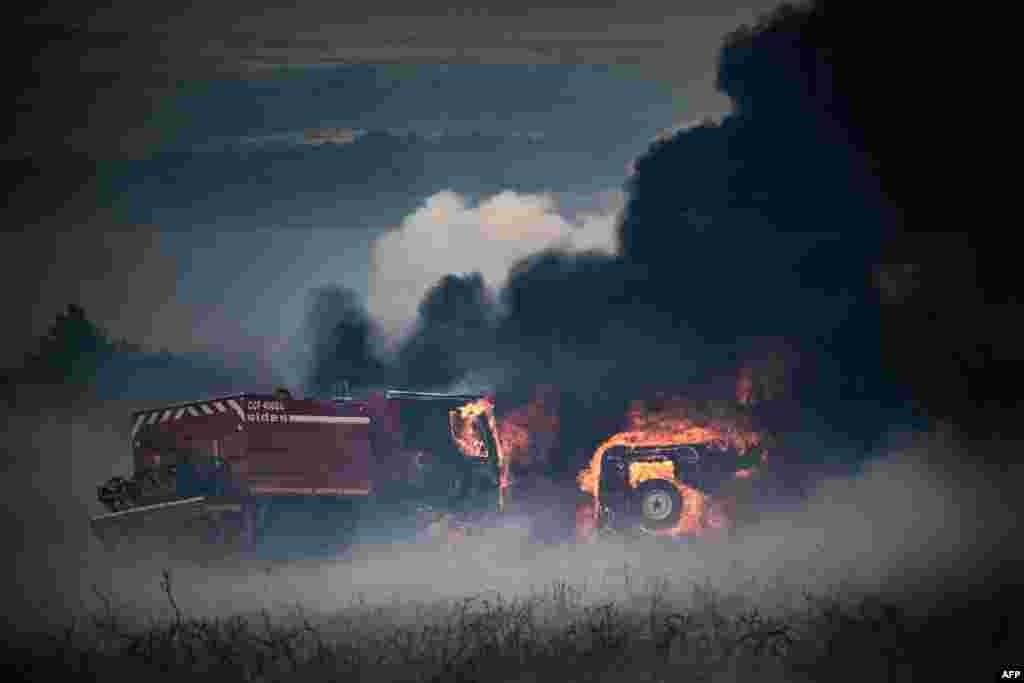 Firefighter trucks are seen burning amid a wildfire on Mont d&#39;Arrees, outside Brasparts, France.