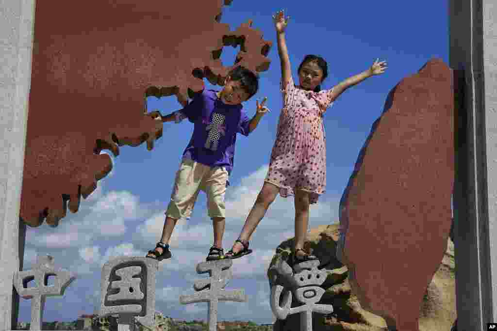 Children pose for photos at the 68-nautical-mile scenic spot, the closest point in mainland China to the island of Taiwan, in Pingtan in southeastern China&#39;s Fujian Province. China conducted &quot;precision missile strikes&quot; Thursday in waters off Taiwan&#39;s coasts as part of military exercises that have raised tensions in the region to their highest level in decades.
