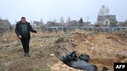 Mwanamme akiwa karibu na kaburi la pamoja katika mji wa Bucha, Ukraine. April 3 2022. Picha AFP