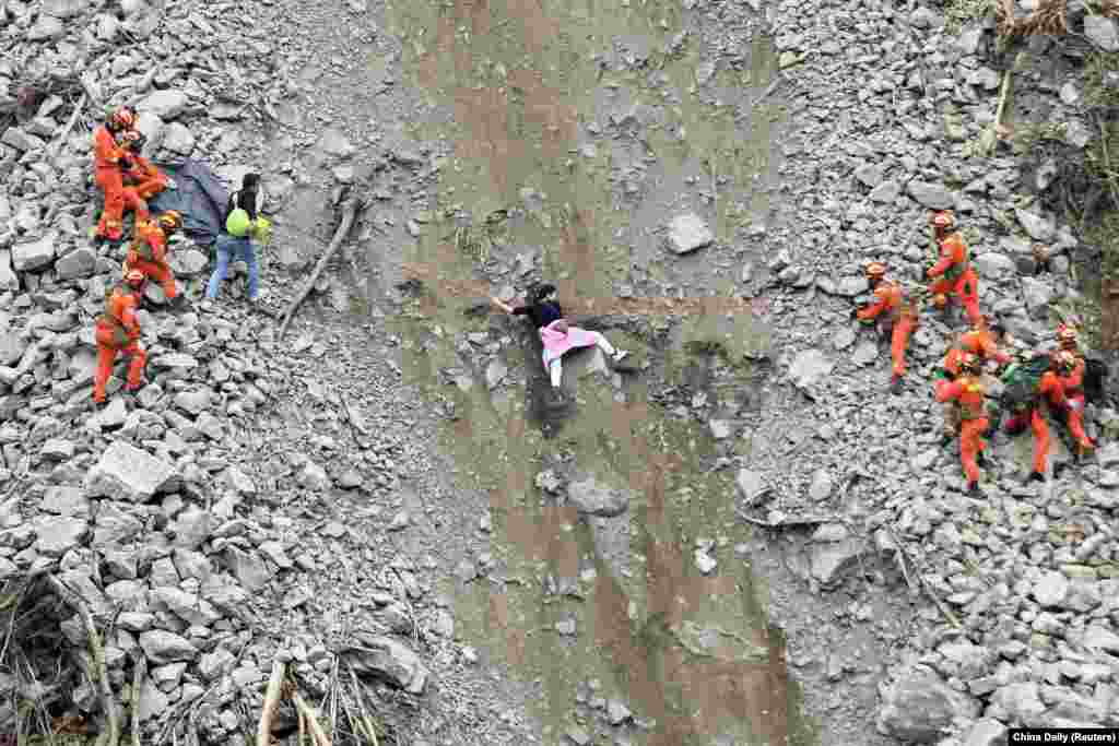 Rescue workers evacuate quake-affected residents at the site of a landslide near Moxi town, following a 6.8-magnitude earthquake in Luding county, Ganzi Tibetan Autonomous Prefecture, Sichuan province, China, Sept. 6, 2022. 