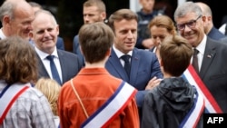 Rais Emmanuel Macron akizungumza na watoto akiwasili kupiga kura kwenye duru ya pili ya uchaguzi wa bunge kaskazini mwa Ufaransa, June 19, 2022. Picha ya AFP