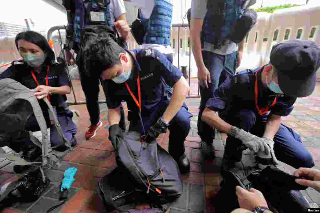 Police officers inspect journalists&#39; bags at a media position outside the Hong Kong West Kowloon railway station, before the 25th anniversary of the former British colony&#39;s handover to Chinese rule, in Hong Kong.