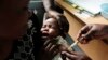 Une mère tient dans ses bras son bébé quo reçoit un nouveau vaccin contre le paludisme dans le cadre d'un essai mené au centre de recherche du projet Walter Reed à Kombewa, dans l'ouest du Kenya, le 30 octobre 2009. (Photo AP/Karel Prinsloo, dossier)