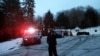 Autos de la policía resguardan la casa del expresidente Bill Clinton y de la excandidata presidencial demócrata Hillary Clinton en Chappaqua, N.Y. después que los bomberos fueron llamados para apagar un incendio. Enero 3 de 2017.