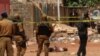 Des éléments forces de sécurité burkinabè se tiennent près du corps d'un suspect jihadiste abattu à Ouagadougou, le 22 mai 2018.(Archives)
