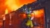 En esta foto del viernes, 6 de julio de 2018, proporcionada por el Departamento de Bomberos del Condado de Santa Bárbara, un bombero lanza agua a una vivienda cerca de Fairview Ave., en Goleta, California. (Mike Eliason / Departamento de Bomberos del Condado de Santa Bárbara vía AP)