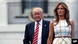 La primera dama Melania Trump camina junto al presidente en el Jardín Sur de la Casa Blanca.