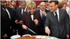 El presidente francés, Emmanuel Macron, y su esposa Brigitte cortan porciones de un tradicional pastel gigante durante una ceremonia en el Palacio del Elíseo en París, Francia, 12 de enero del 2018.
