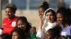 La ganadora del Premio Nobel de la Paz, Malala Yousafzai, posa con adolescentes de Complexo da Penha, que trabajan con la organización de fútbol Street Child United, en la playa de Copacabana en Río de Janeiro, Brasil, el 11 de julio de 2018.