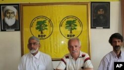 Serokê BDP'ê Halîs Yurtsever û rêvebirên bajarê li avahîya partîyê xwane dibin.
