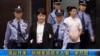 中央电视台播放的画面显示垮台的中国政治人物薄熙来的妻子谷开来和薄家勤务人员张晓军被带入中国东部的合肥市中级人民法院，他们被控害死了英国商人海伍德(2012年8月9日)