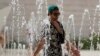 Un turista se refresca en una fuente pública en Lisboa, Portugal, el 4 de agosto de 2018. REUTERS/Rafael Marchante. Una ola de calor en Europa con temperaturas históricas ha comenzado a ceder, pero ha provocado sequía y fuegos en varios países, y en la región Algarve de Portugal.